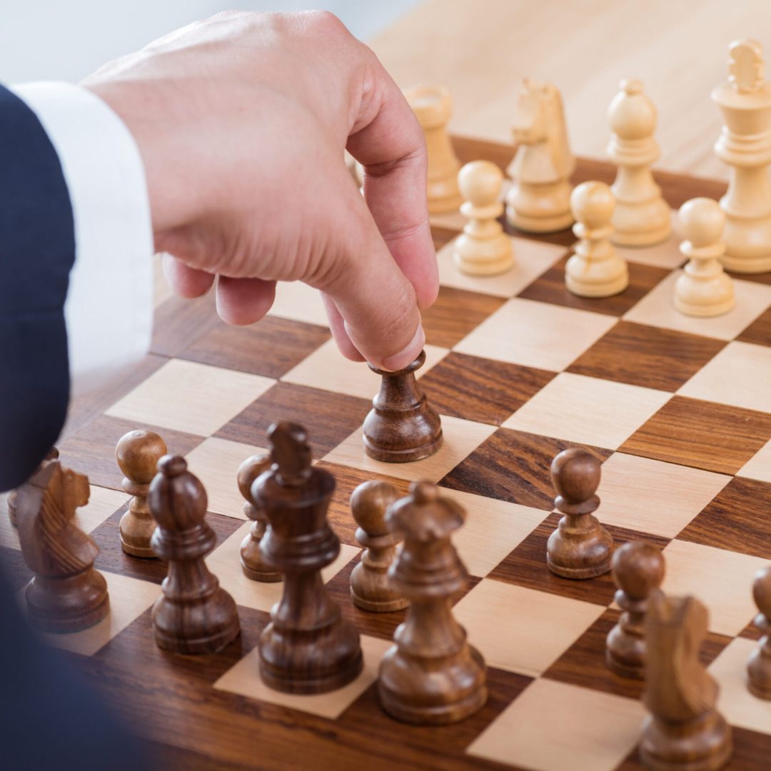 partial view of businessman holding chess figure while playing chess alone